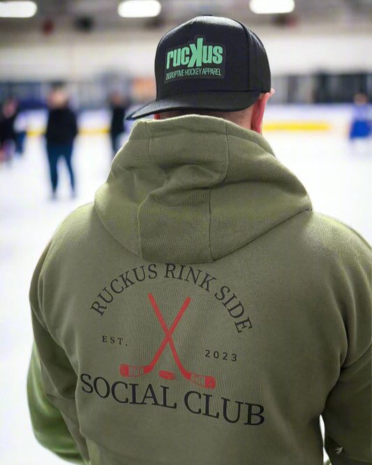 Person wearing a green hoodie with 'Ruckus Rink Side Social Club' text and graphics
