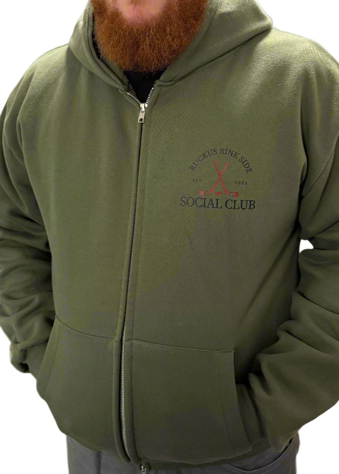 Man wearing a green hoodie with a logo in an indoor setting
